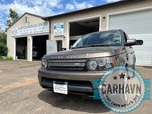 A range rover is parked in front of a garage.