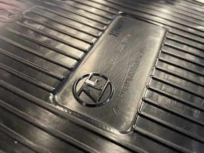 A close up of a black rubber mat with a zf logo on it.