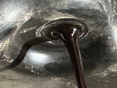 A close up of a hole in a sink with liquid coming out of it.