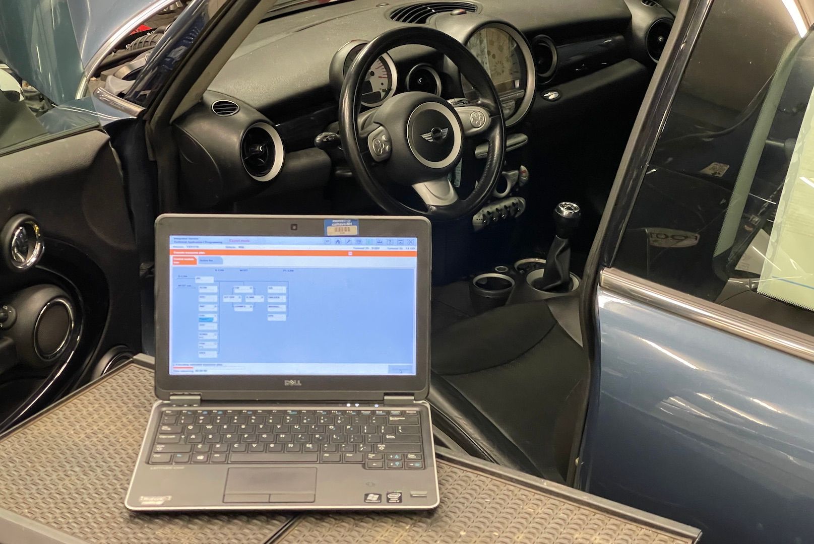 A laptop is sitting on a table next to a car