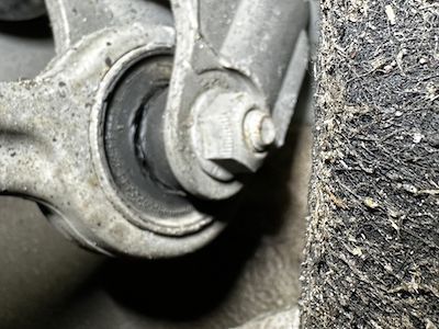 A close up of a suspension arm on a car.