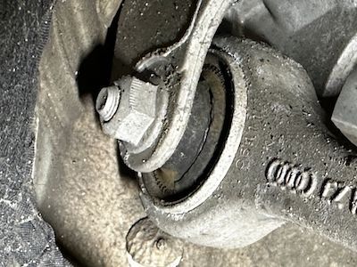 A close up of a metal object with a nut on it.