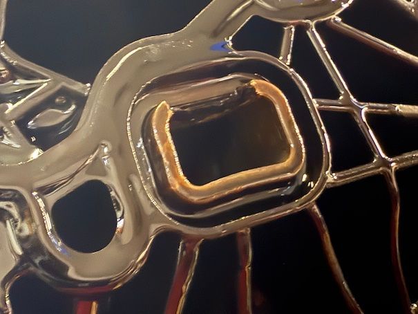 A close up of a metal object with a black background
