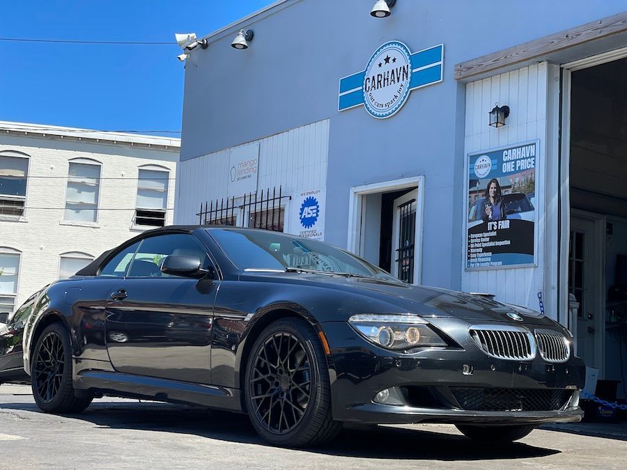 A black sports car is parked in front of a building.