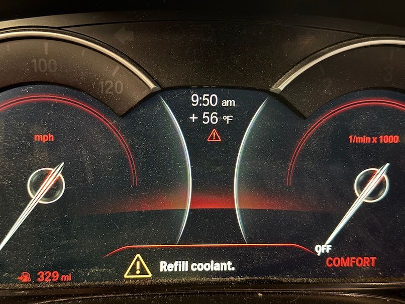 A close up of a car dashboard that says refill coolant