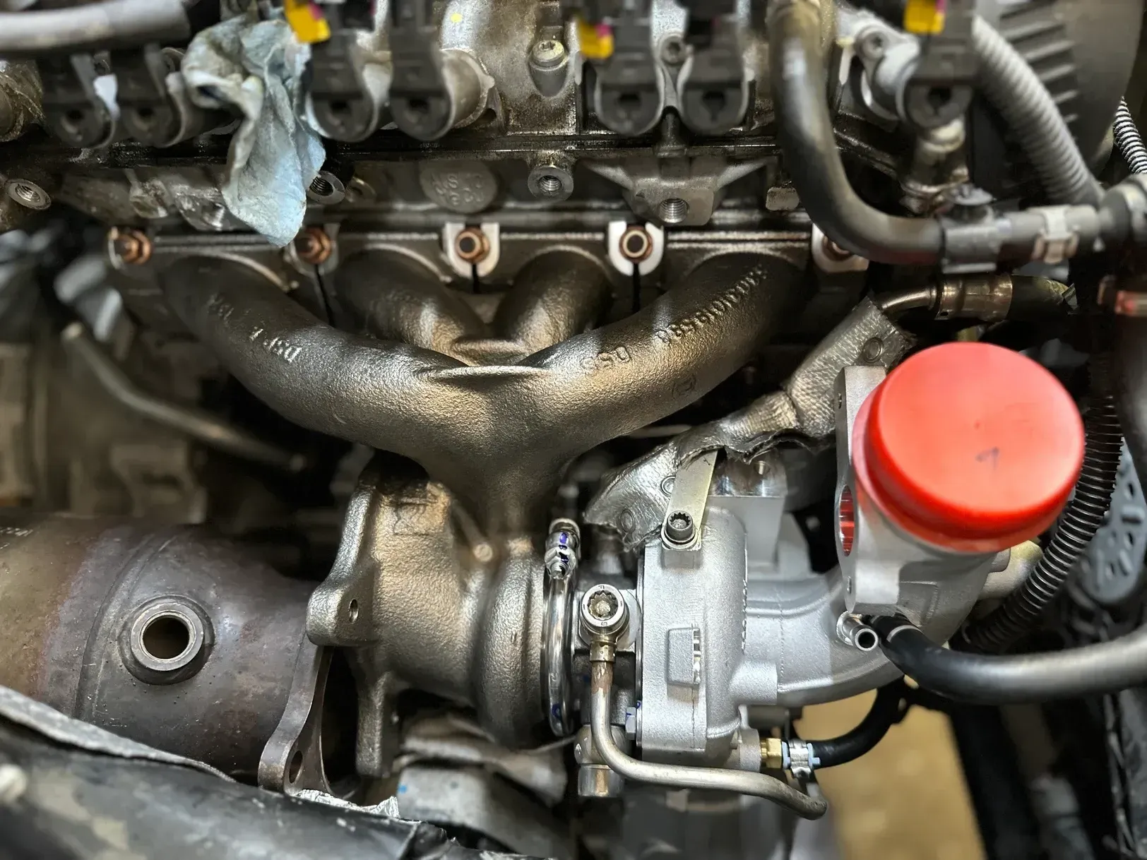 A close up of a car engine with a red cap on it.