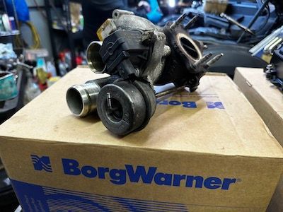 A borgwarner turbocharger is sitting on top of a cardboard box