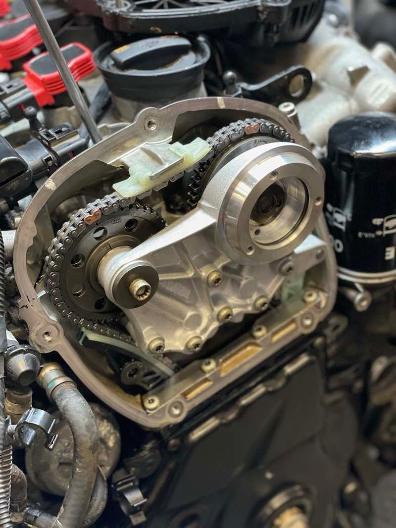 A close up of a motorcycle engine with a chain on it.