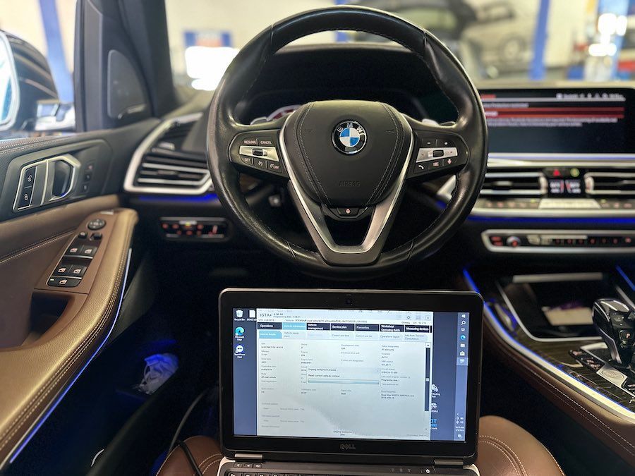 A laptop is sitting in the driver 's seat of a bmw x5.