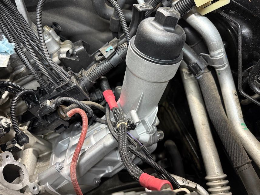 A close up of a car engine with a oil filter