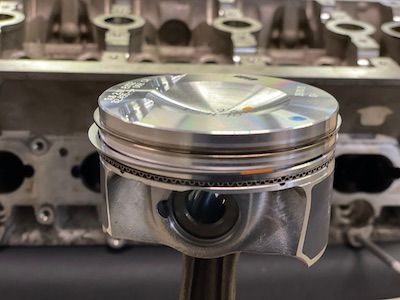 A close up of a piston sitting on top of a cylinder head.