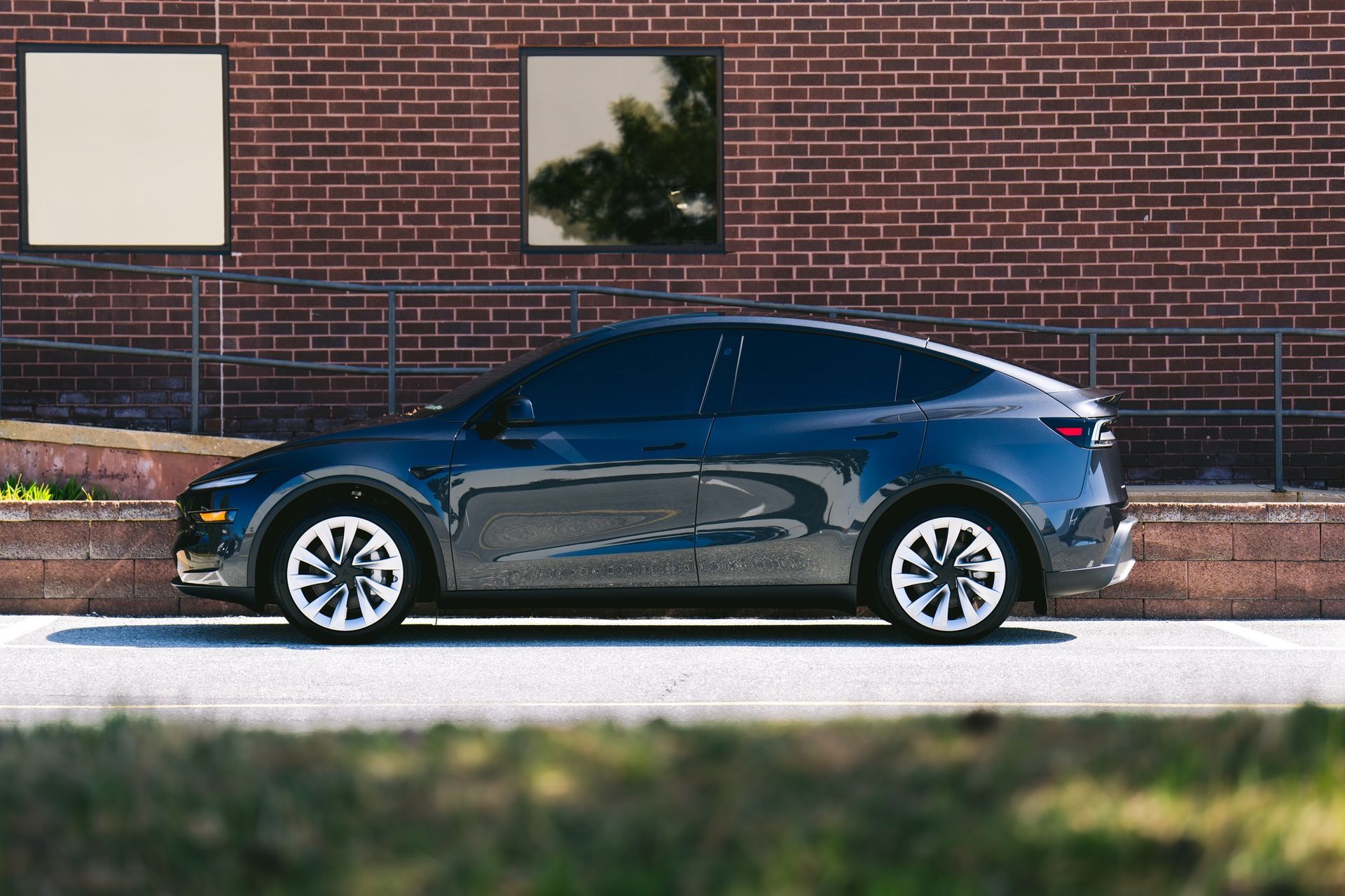 Gray Tesla Model Y with ceramic coating parked outside showcasing high-gloss protected finish