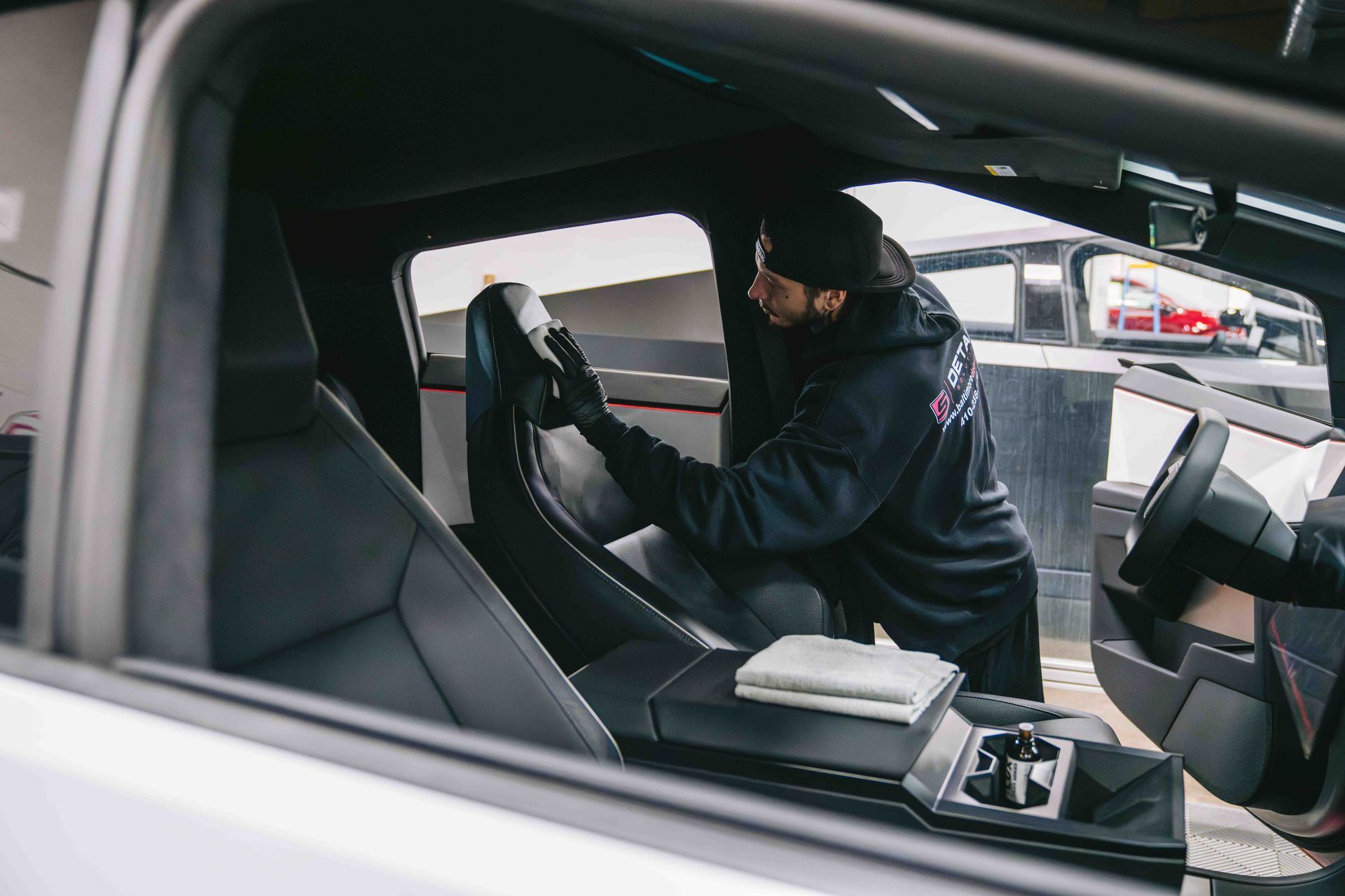 A man is cleaning the seats of a tesla model s.