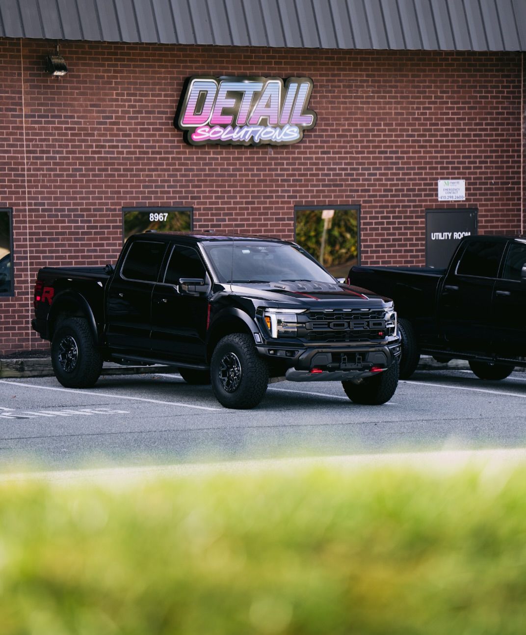 Black Ford Raptor with paint protection film parked outside Detail Solutions auto detailing shop