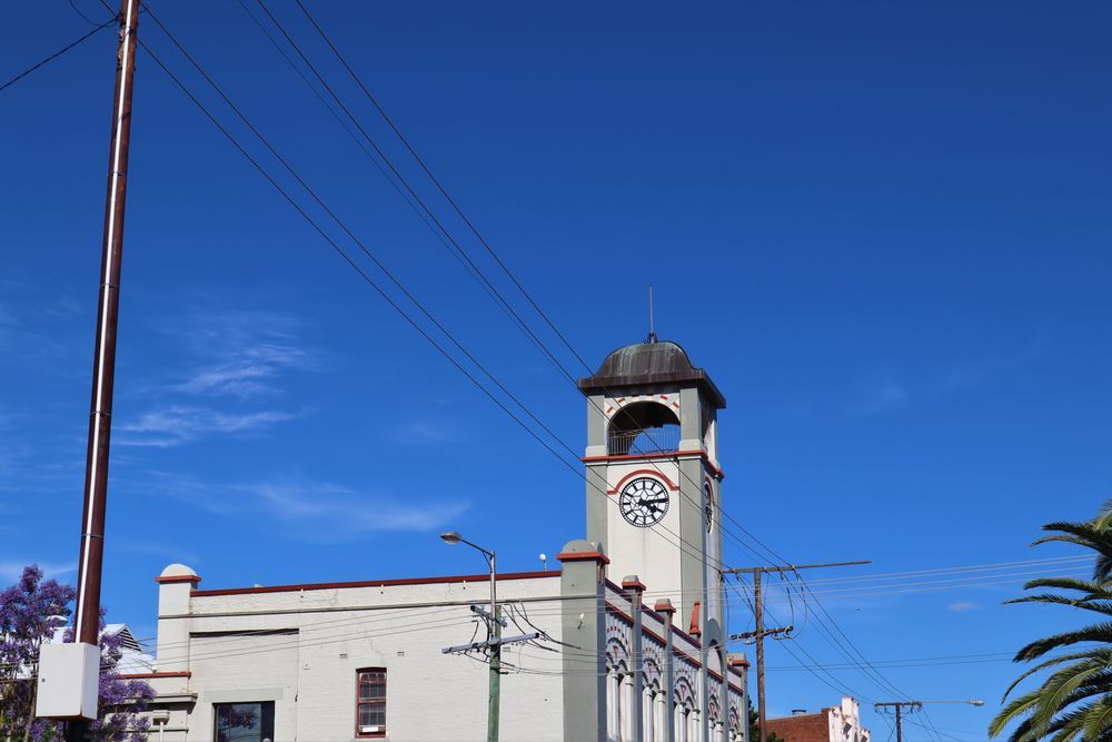 A Large White Building With A Clock Tower On Top Of It — Cessnock Pet & Greyhound Supplies in Gunnedah, NSW