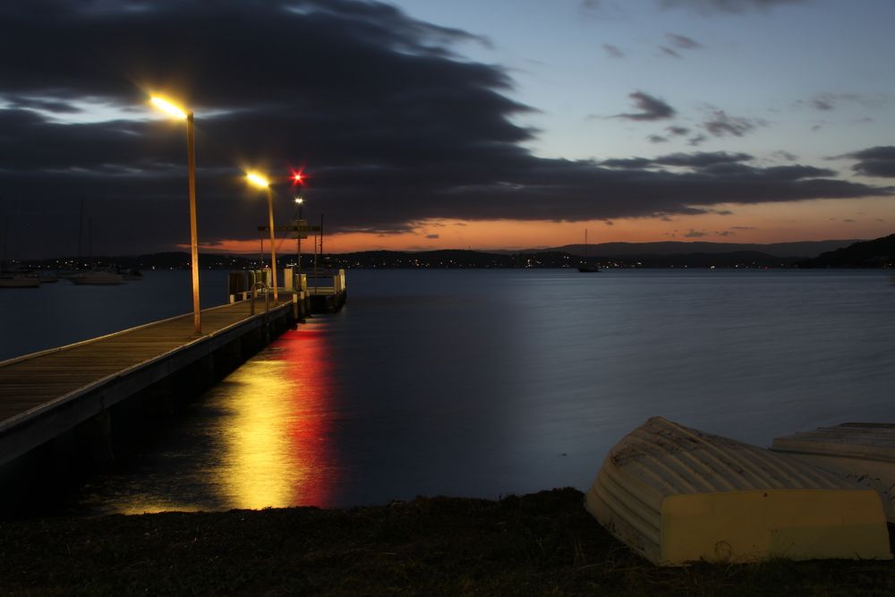 A Dock At Night With A Boat In The Foreground — Cessnock Pet & Greyhound Supplies in Lake Macquarie, NSW