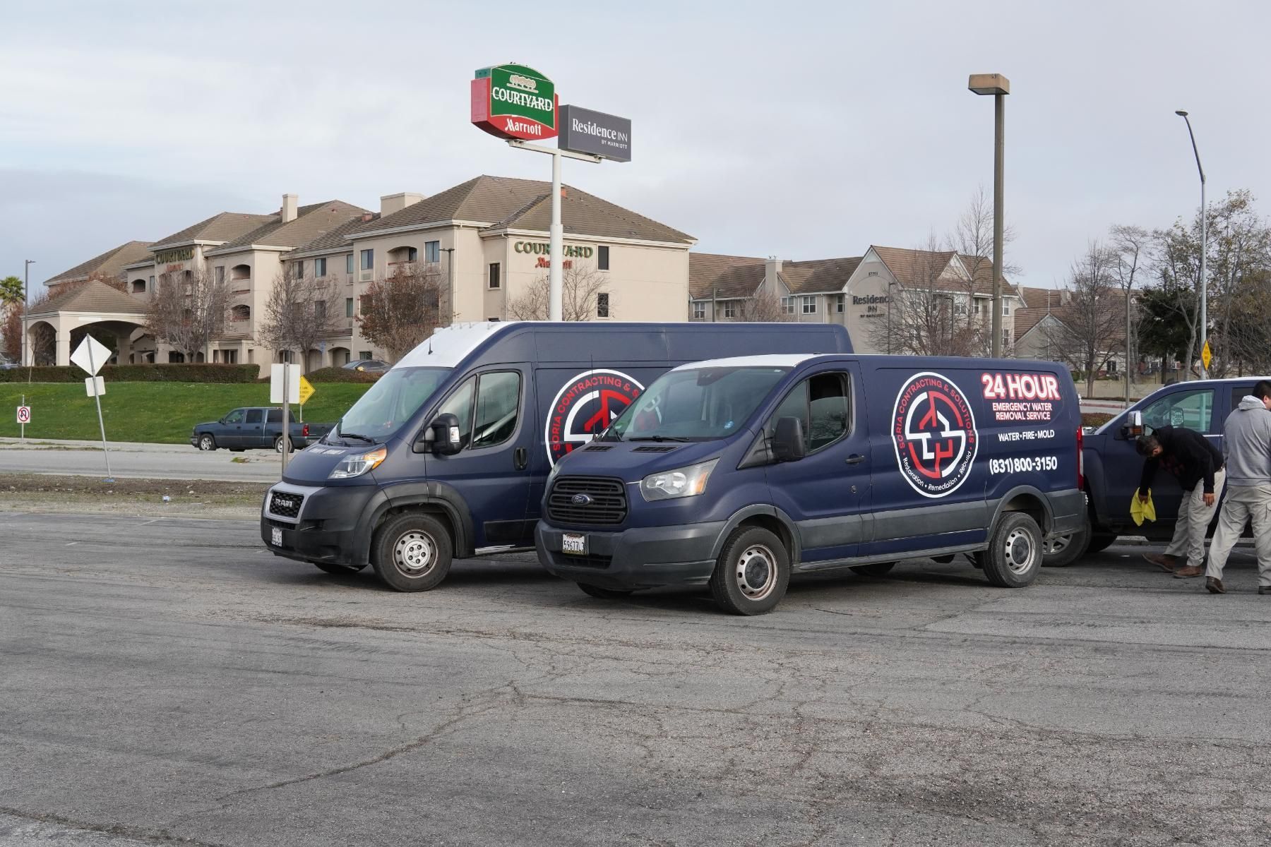 a man in a blue shirt is smiling in front of a 24 hour van .