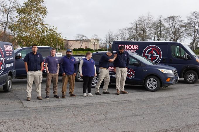 a man in a blue shirt is smiling in front of a 24 hour van .