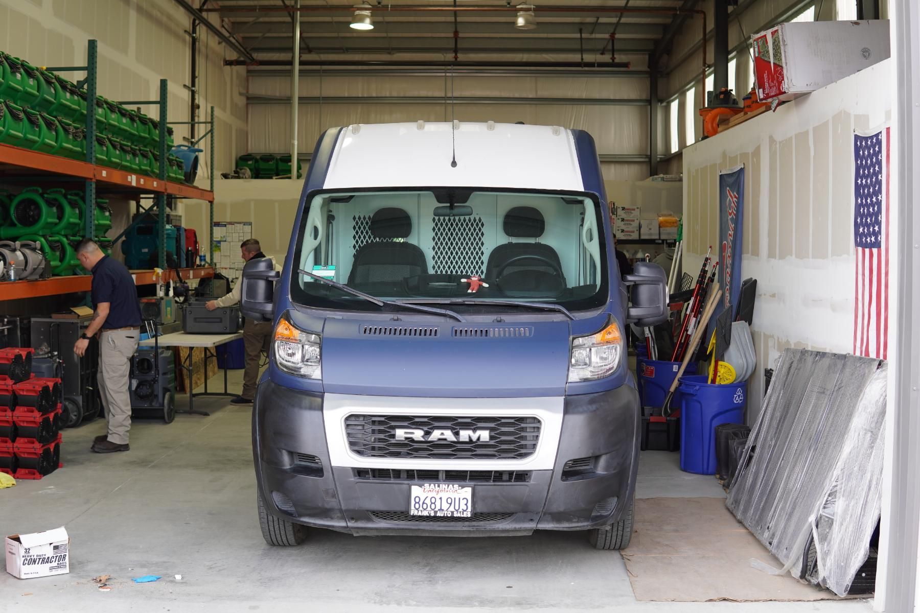 a man is carrying two red boxes in a room .
