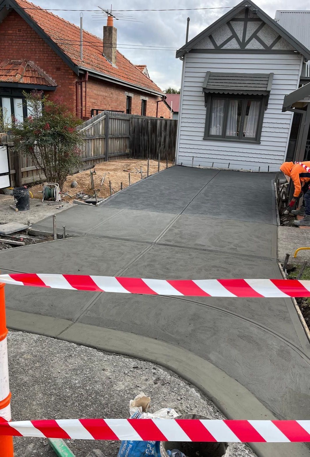 A concrete driveway is being built in front of a house.