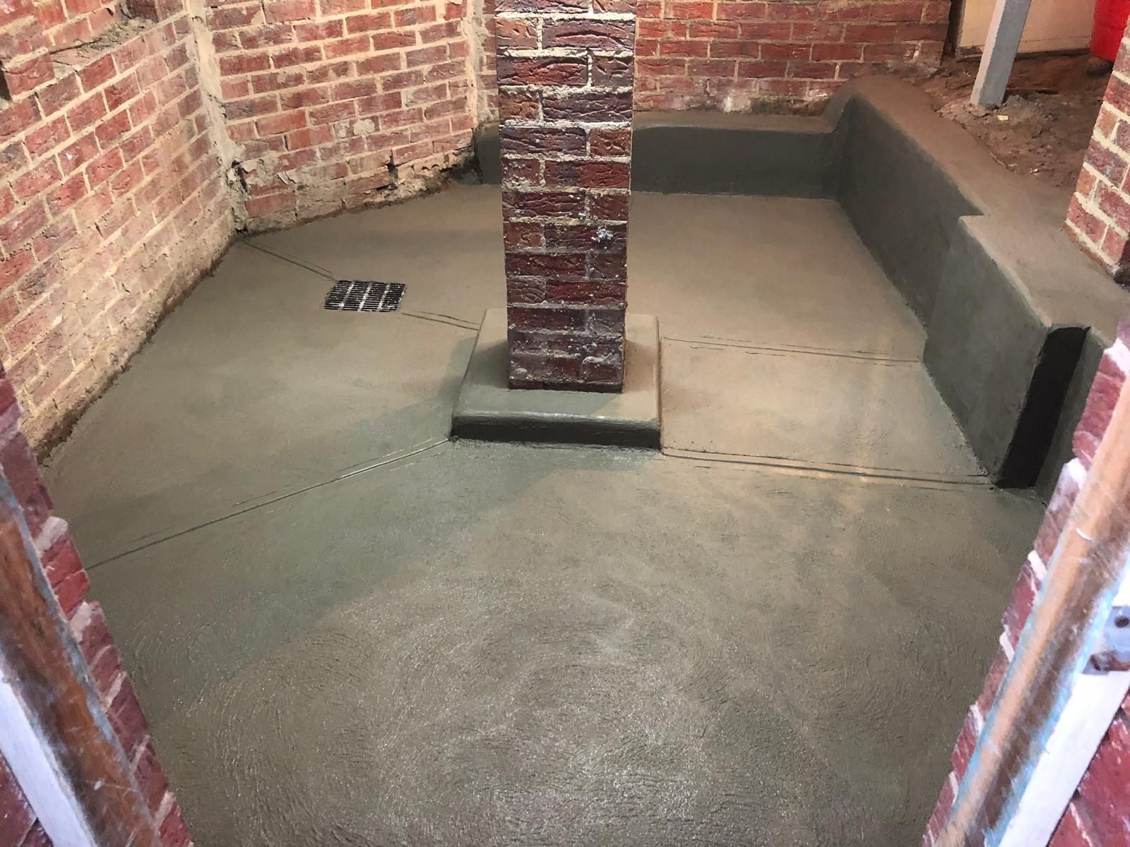 A room with a brick wall and a concrete floor.