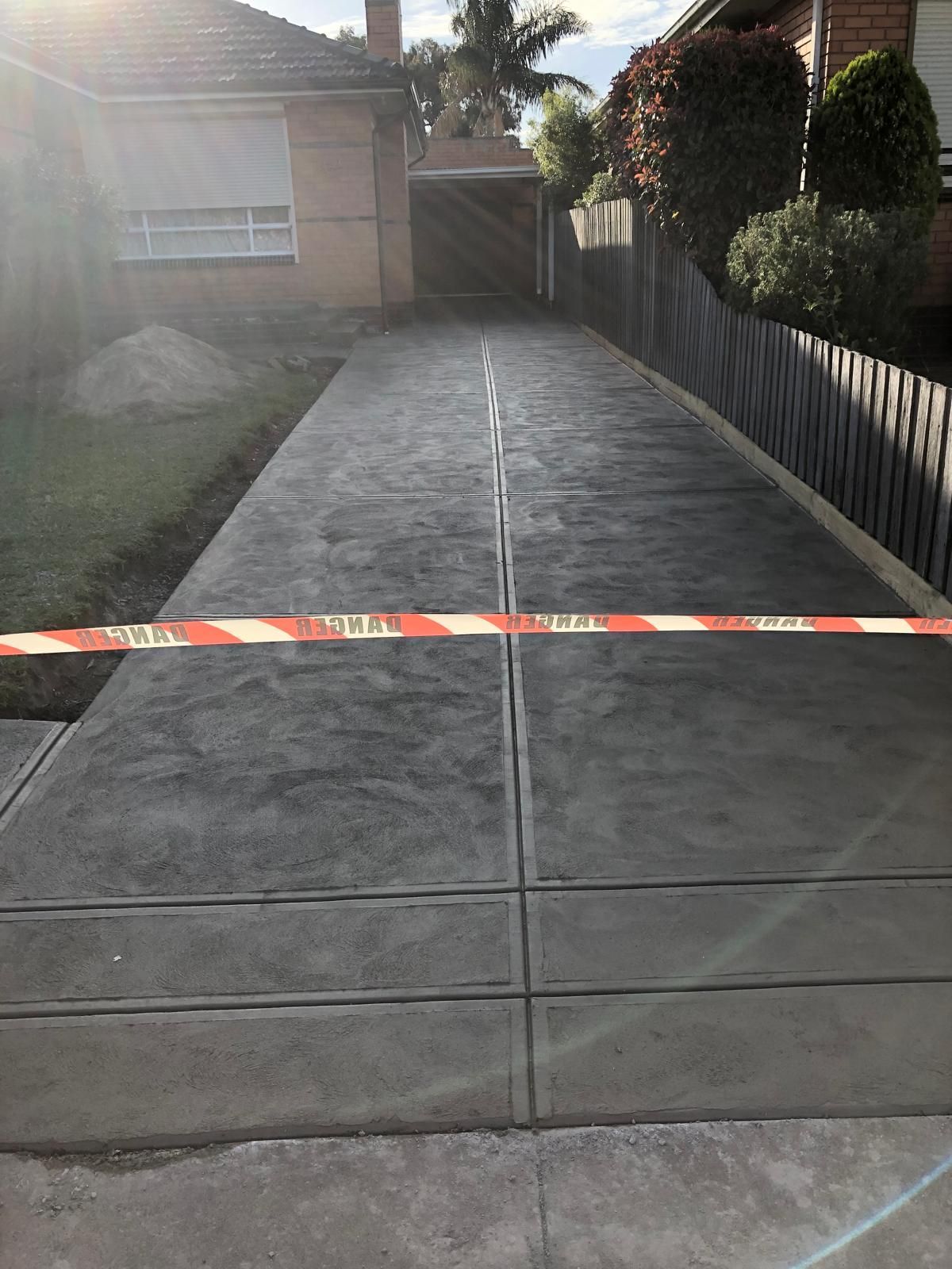 A concrete driveway is being built in front of a house.
