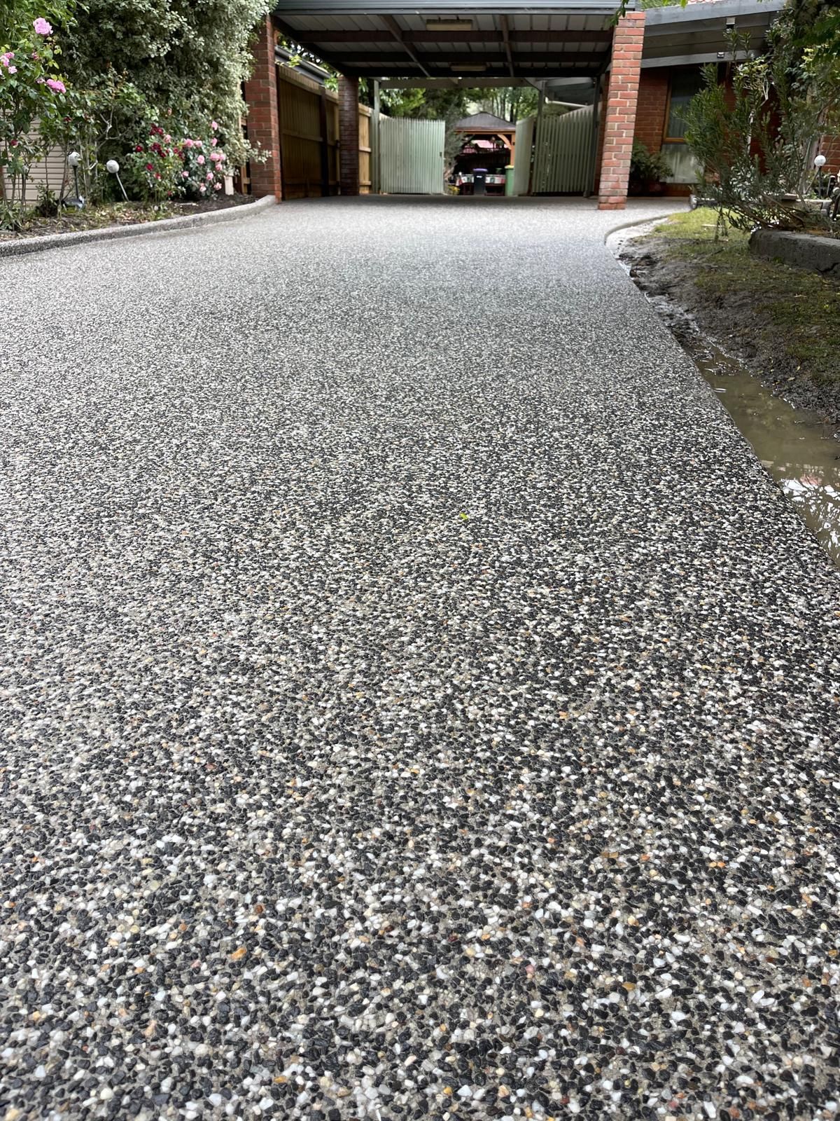 A close up of a gravel driveway leading to a garage.