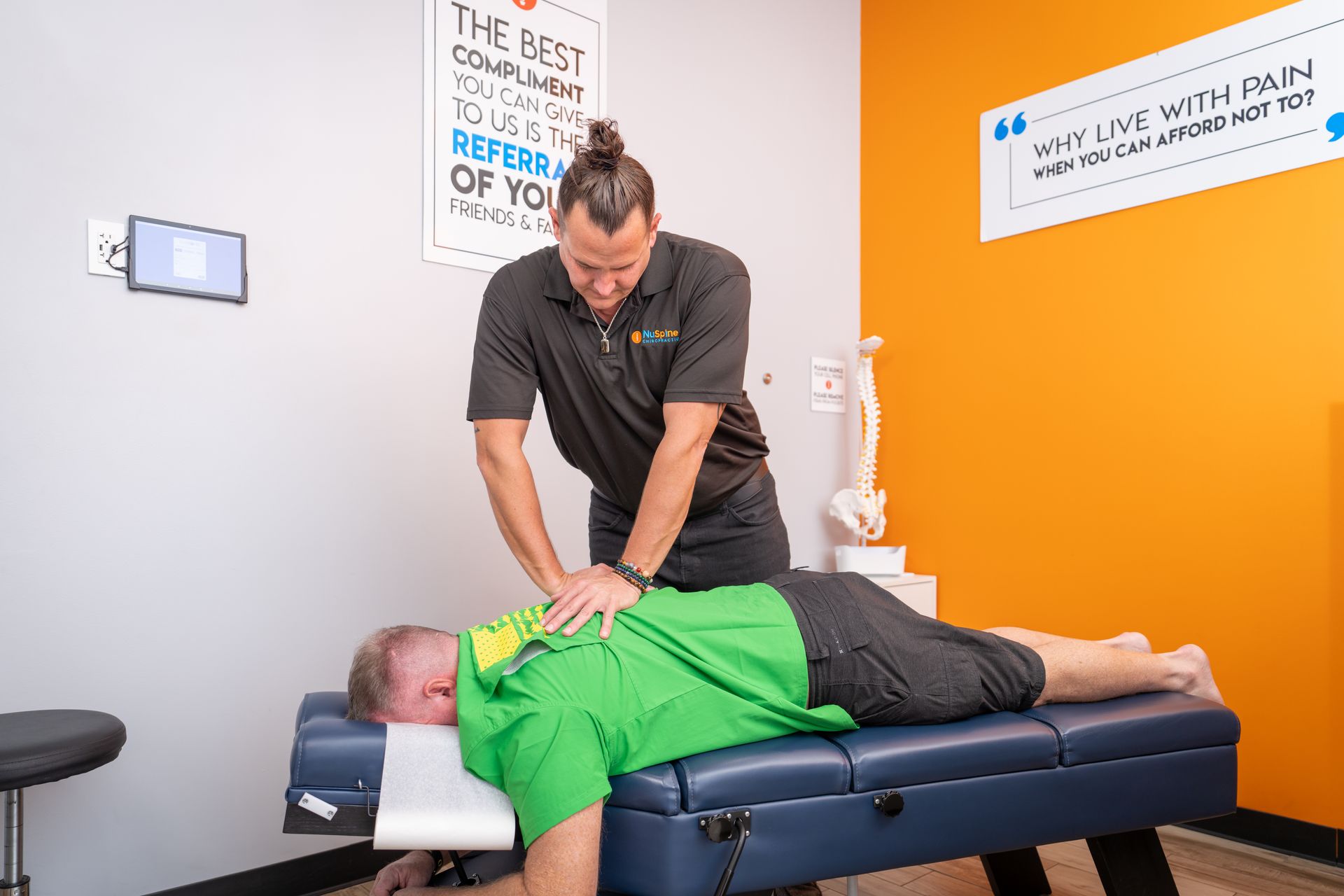 A man is laying on a table getting a massage from a chiropractor.