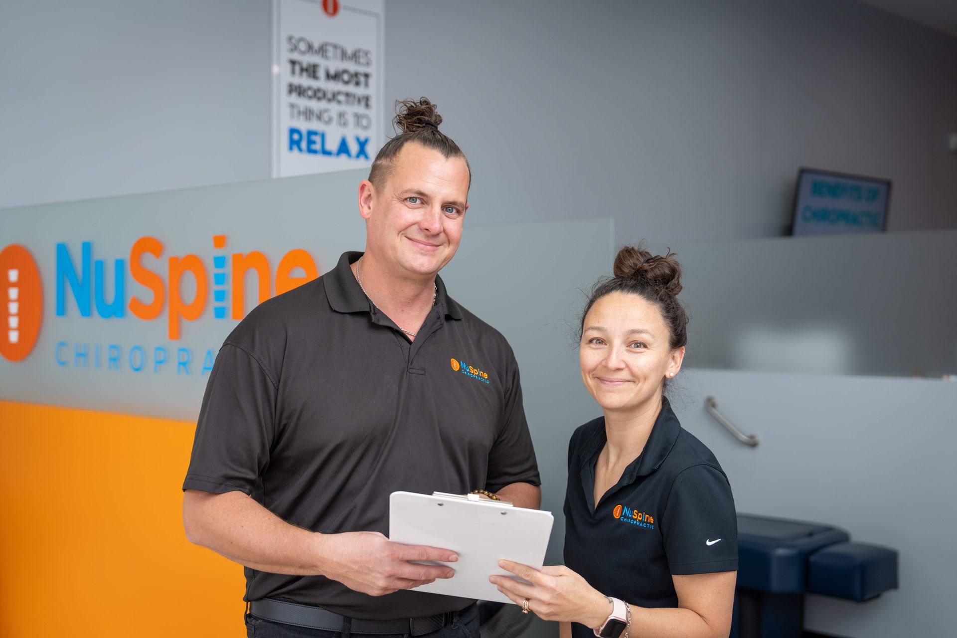 A man and a woman are standing next to each other in a chiropractic office.