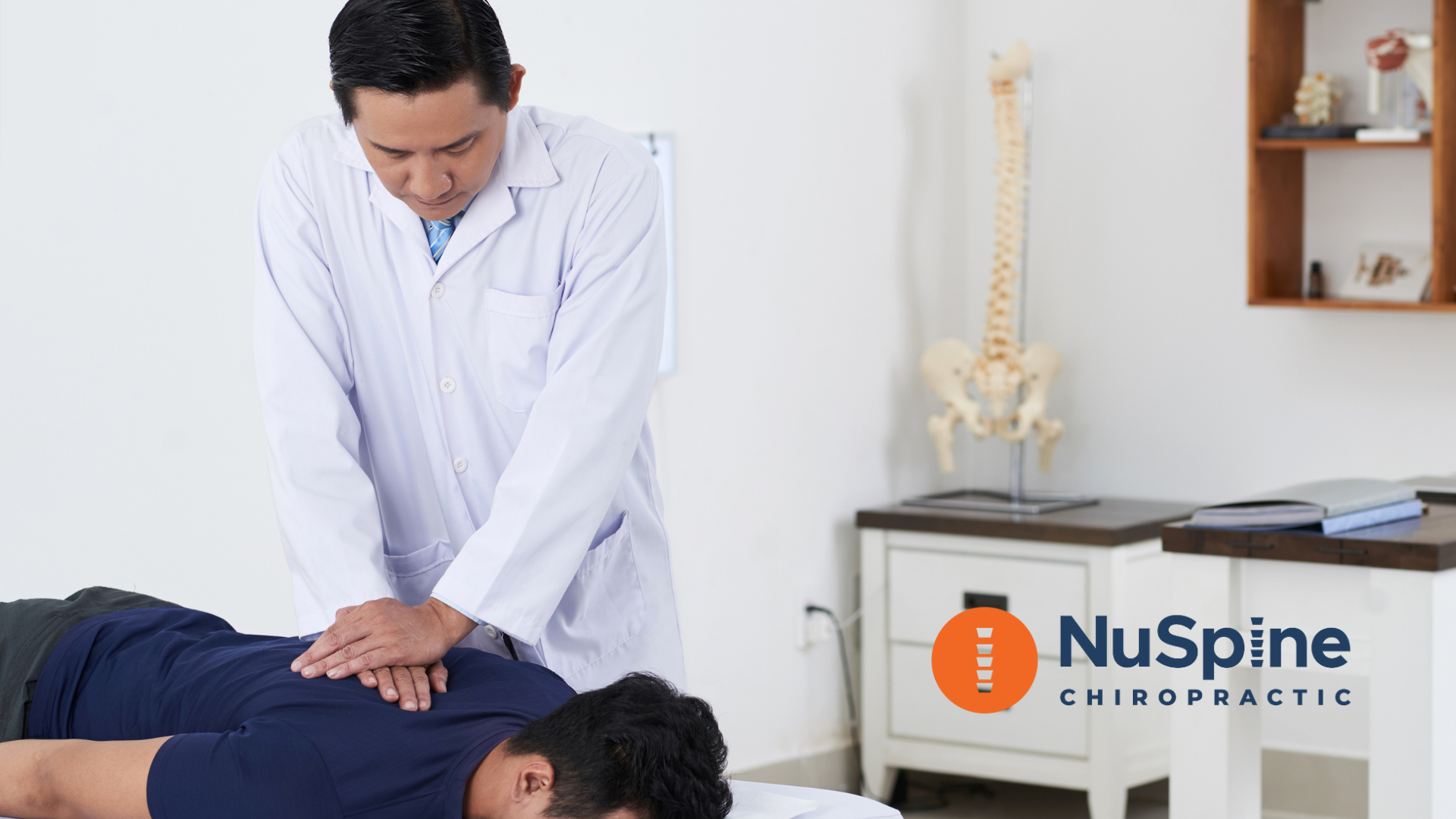 Doctor pointing at a spine model, explaining spinal anatomy.