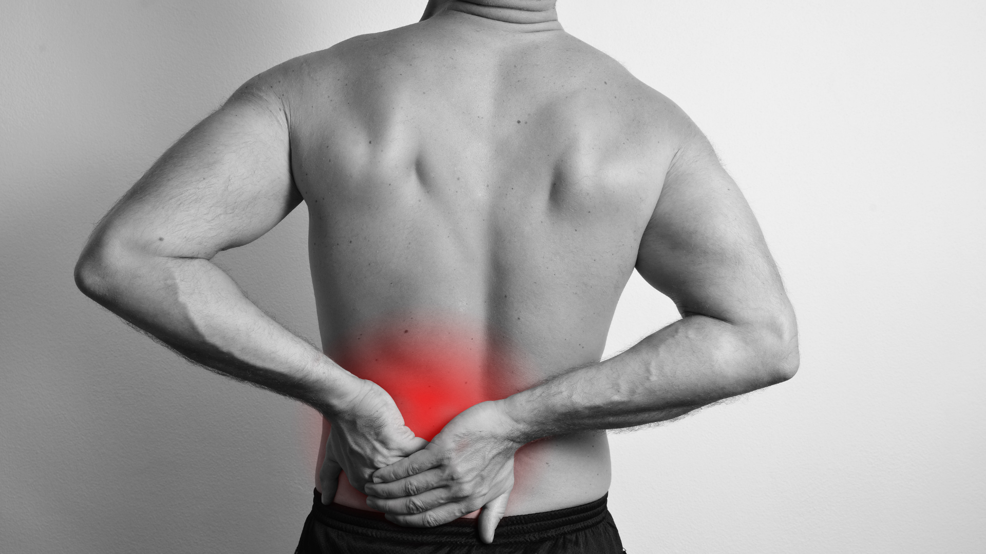 Man holding lower back, red highlight indicating pain.