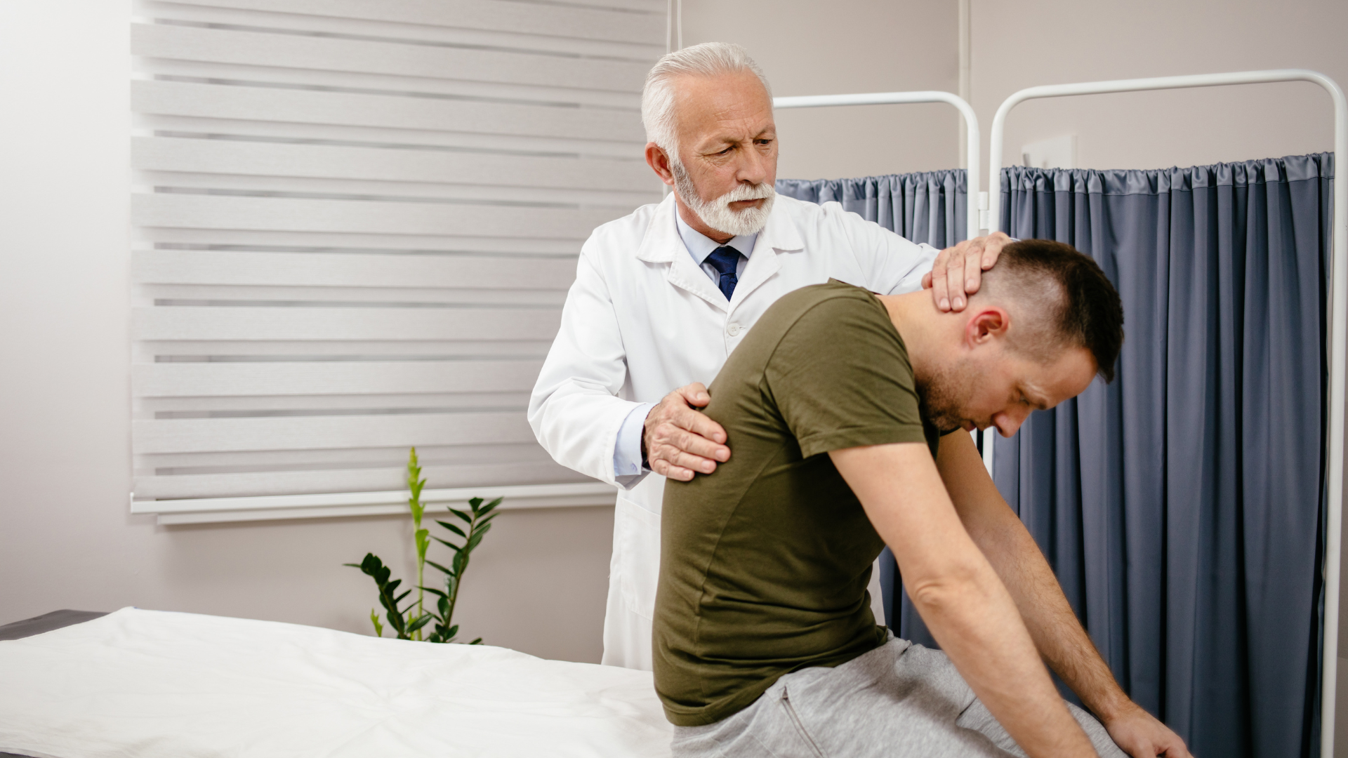 Doctor examining a patient's neck and back in a medical setting.