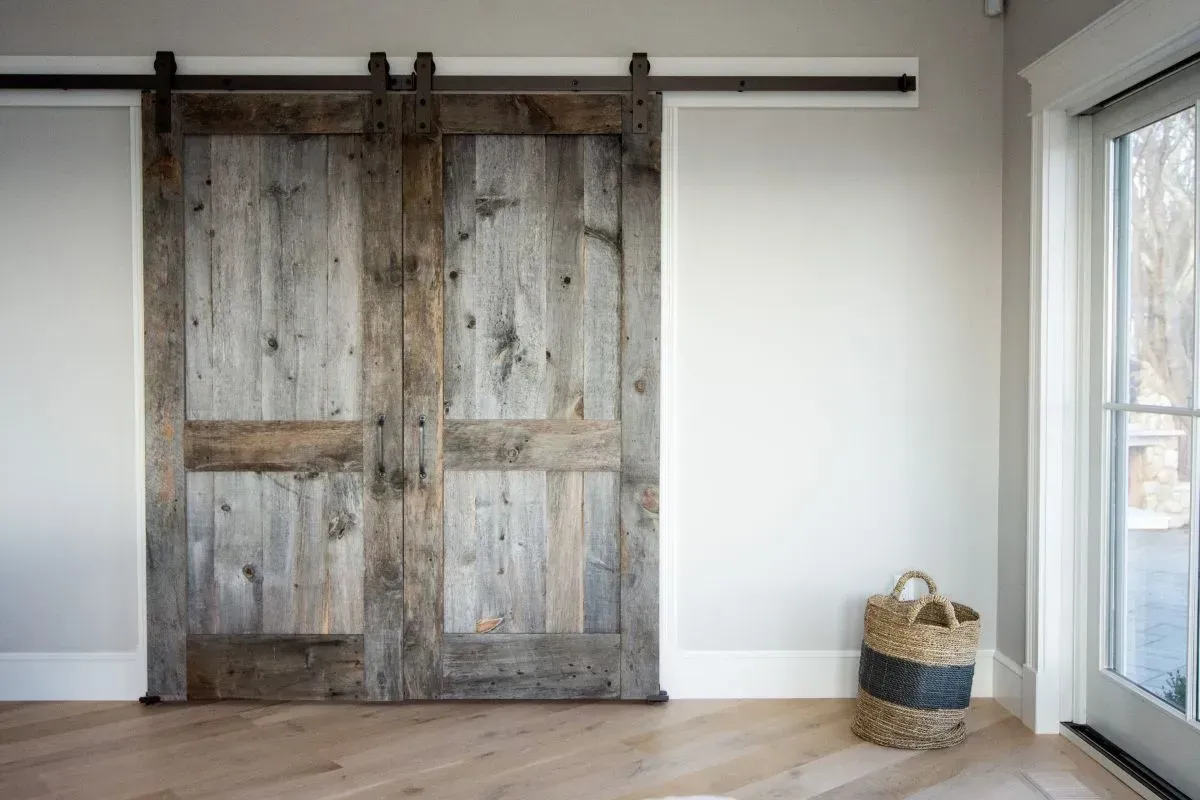 A room with sliding barn doors and a basket on the floor.