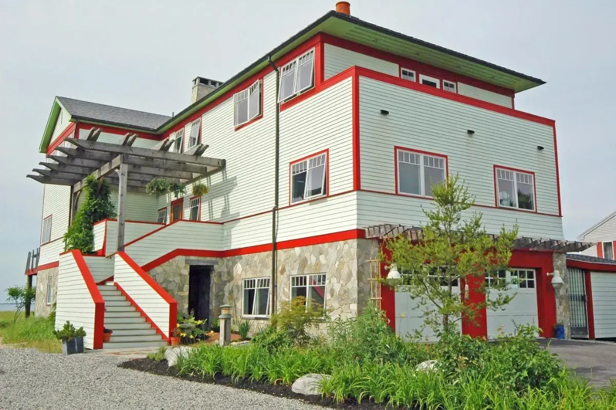 A large white and red house with stairs leading up to it