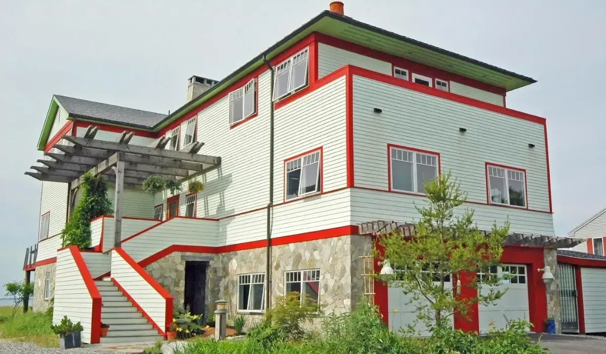 A large white and red house with stairs leading up to it