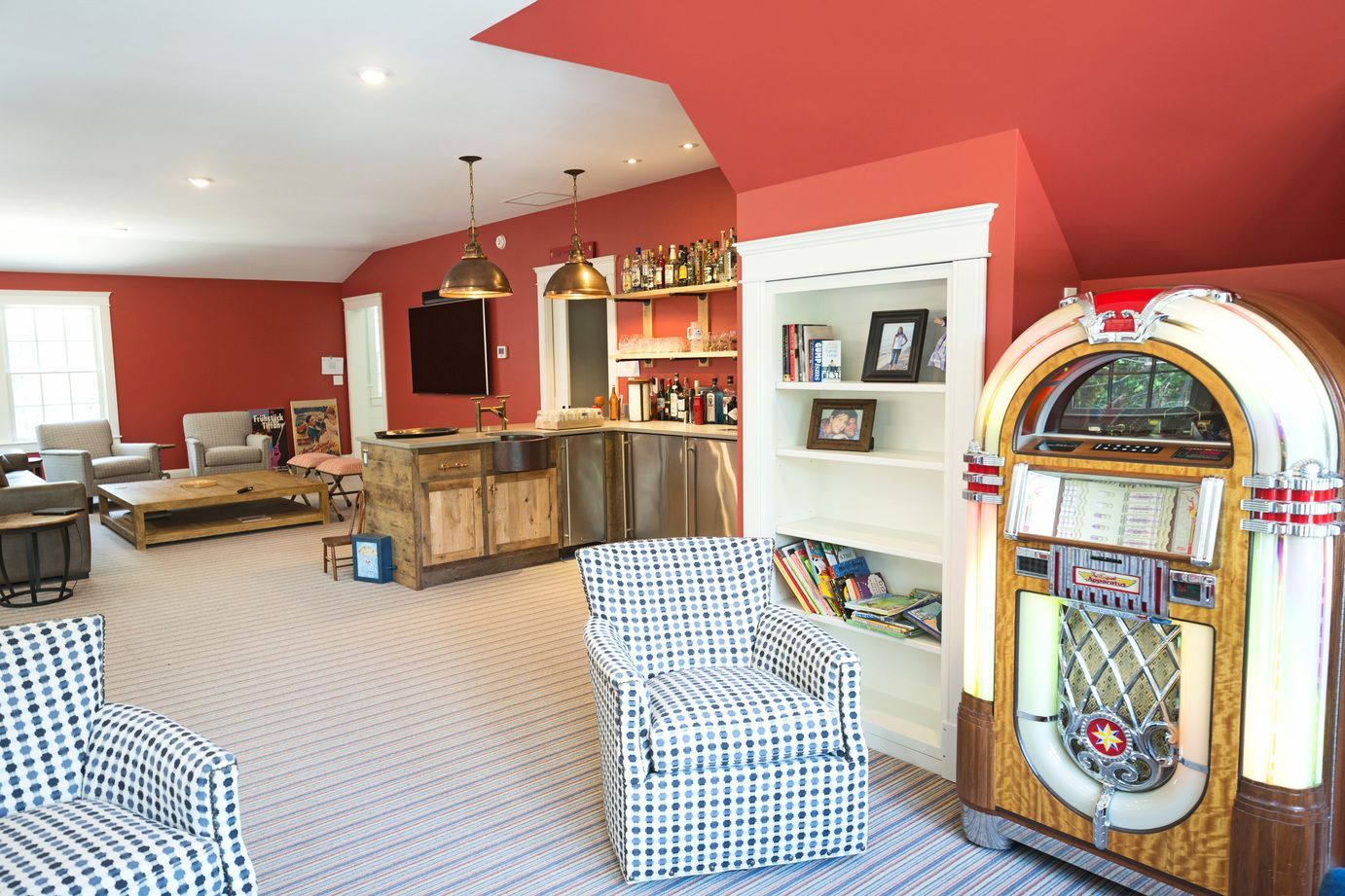 A living room with red walls and a jukebox