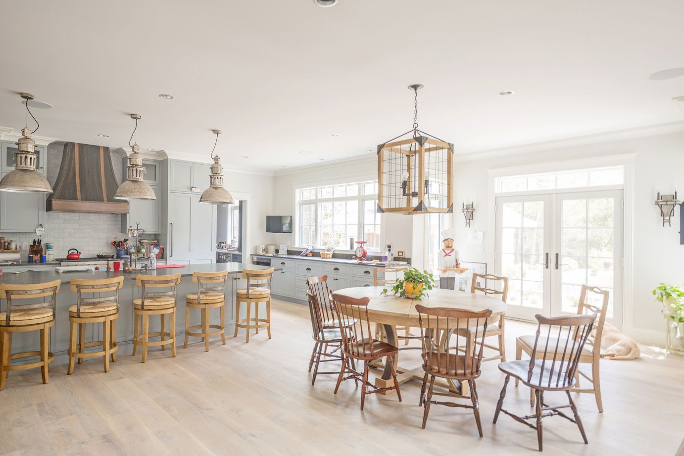 A kitchen and dining room in a house with tables and chairs.