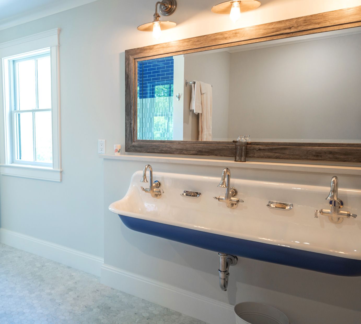 A bathroom with three sinks and a large mirror