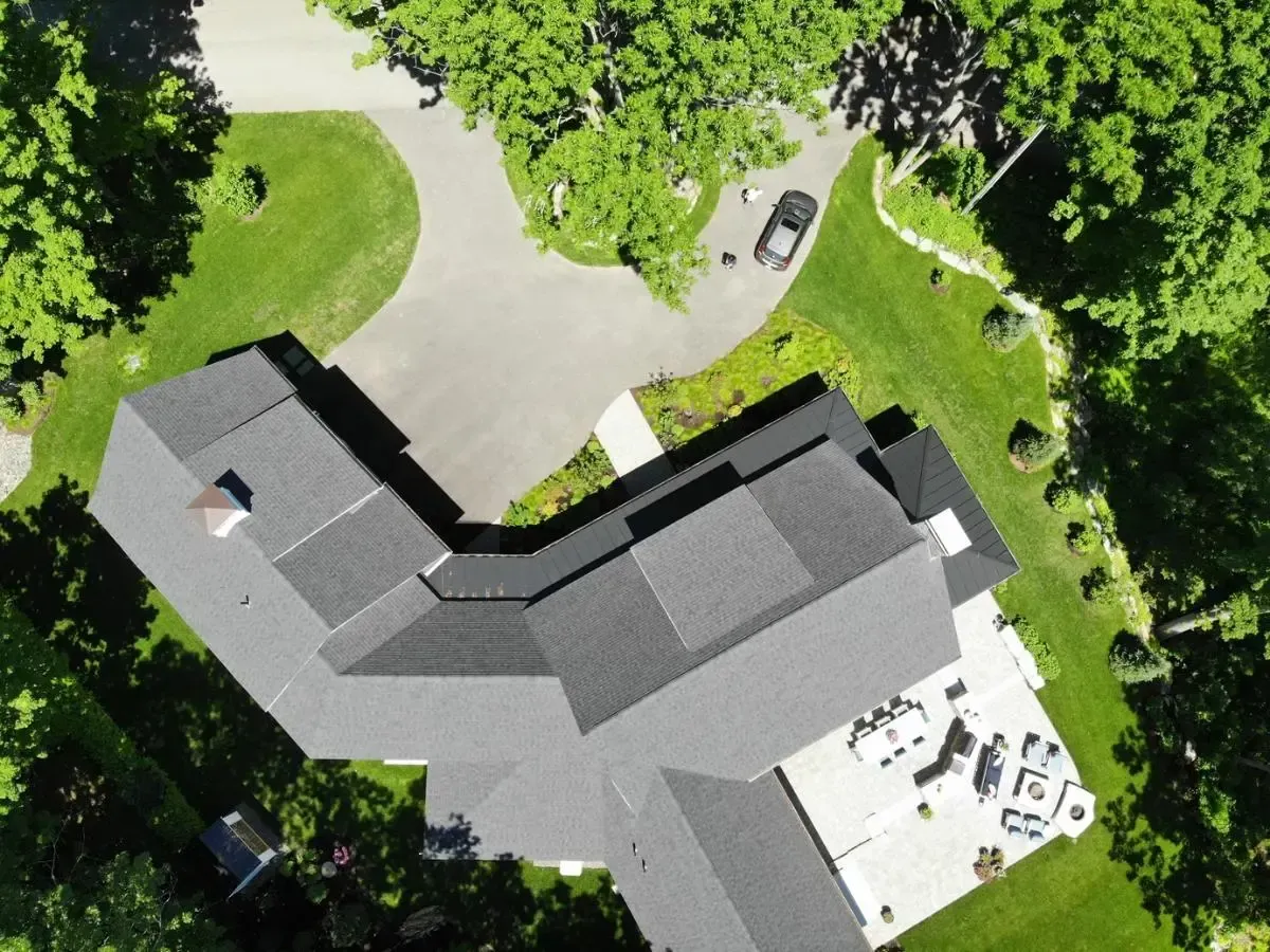 An aerial view of a house with a car parked in the driveway
