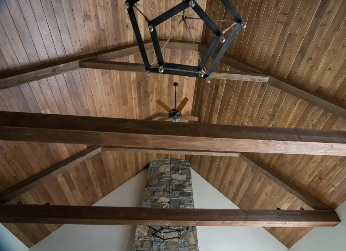 A ceiling with wooden beams and a ceiling fan