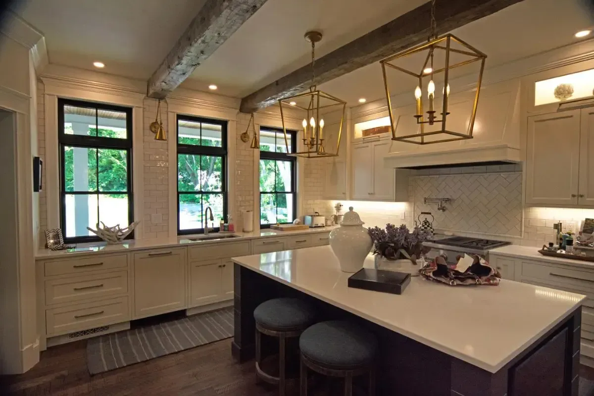 A kitchen with white cabinets and a large island in the middle.