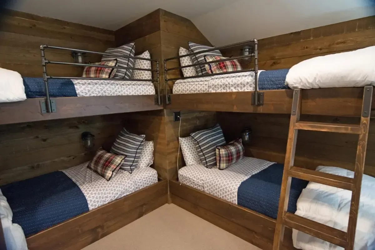 A room with four bunk beds and a ladder.