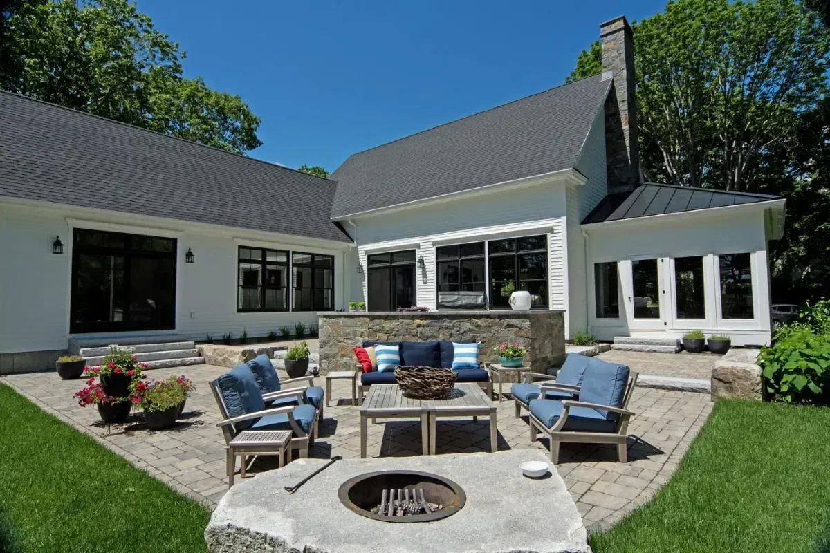 A large white house with a fire pit in front of it