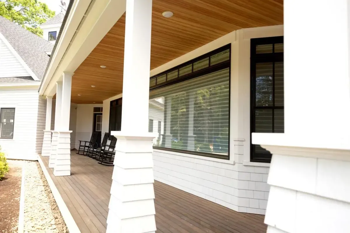 custom designed porch with pillars in white and wood ceiling.