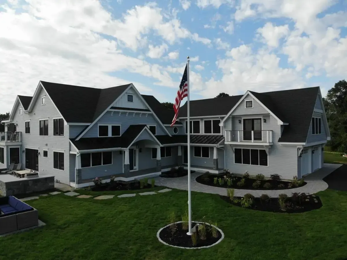 A large white house with a flag pole in front of it