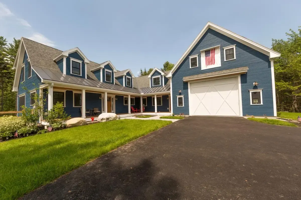 A large blue house with a garage and a porch