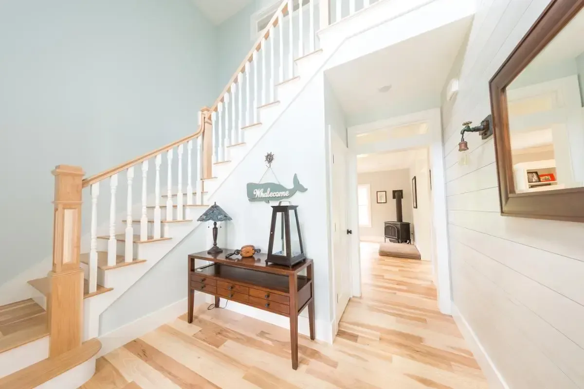 A hallway with stairs and a welcome sign on the wall