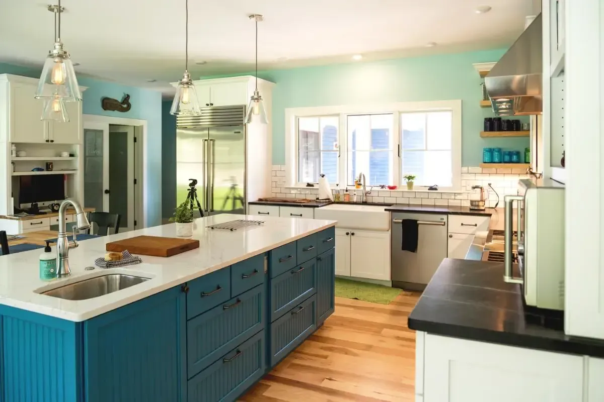 A kitchen with blue cabinets and white counter tops