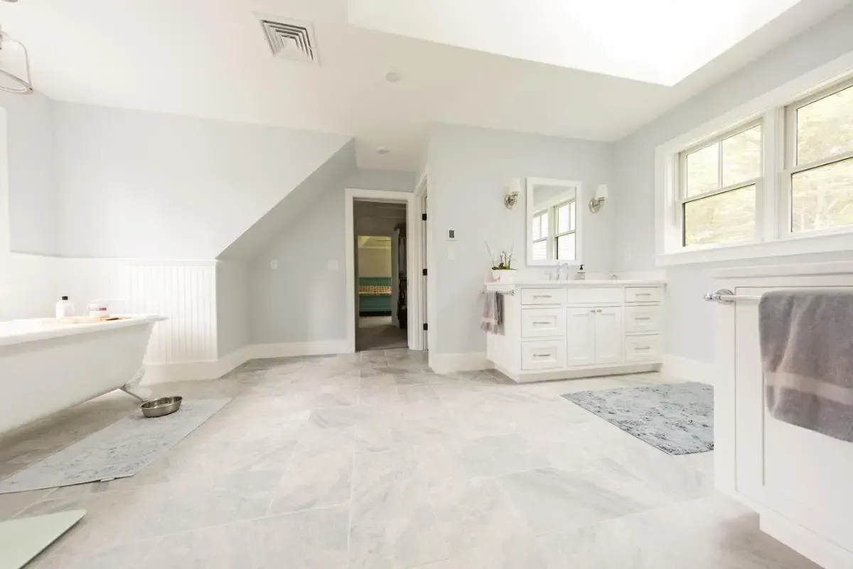 A bathroom with a bathtub , sink , and mirror.