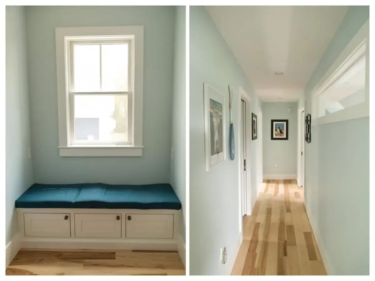A hallway with a window and a bench with a blue cushion
